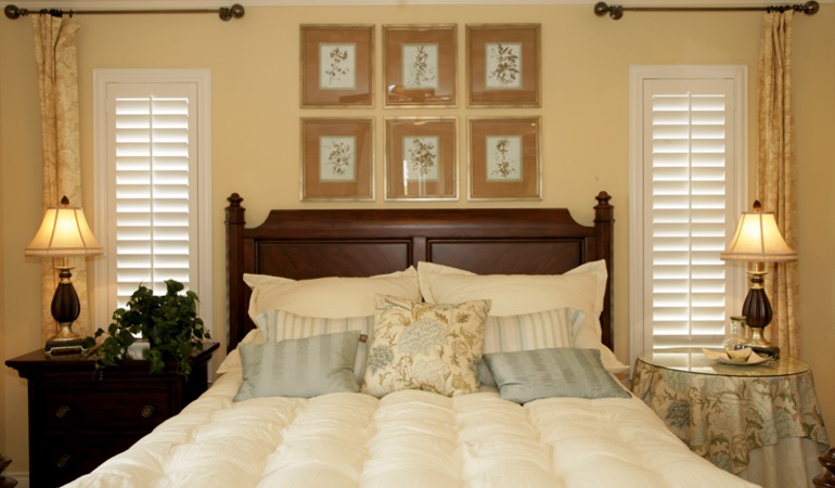 Bedroom with two tall plantation shutters on either side of bed in Philadelphia 